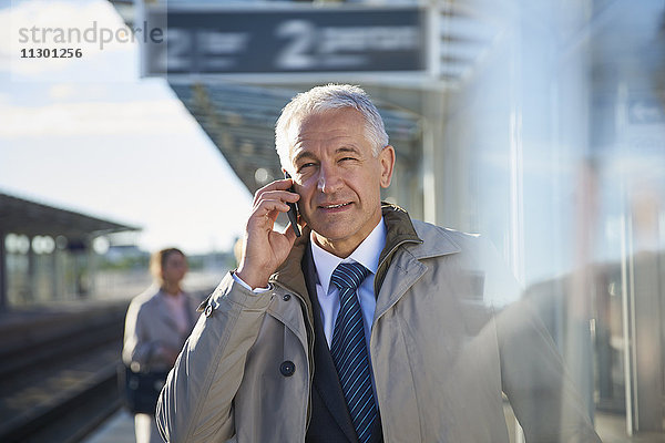 Geschäftsmann beim Telefonieren außerhalb des Flughafens