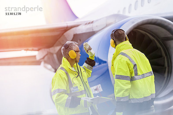 Bodenpersonal am Flughafen spricht in der Nähe des Flugzeugs