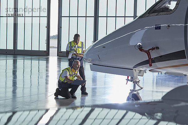 Bodenpersonal der Flugsicherung untersucht Firmenjet im Flugzeughangar