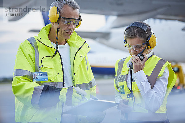 Bodenpersonal der Flugsicherung mit Zwischenablage auf dem Rollfeld des Flughafens