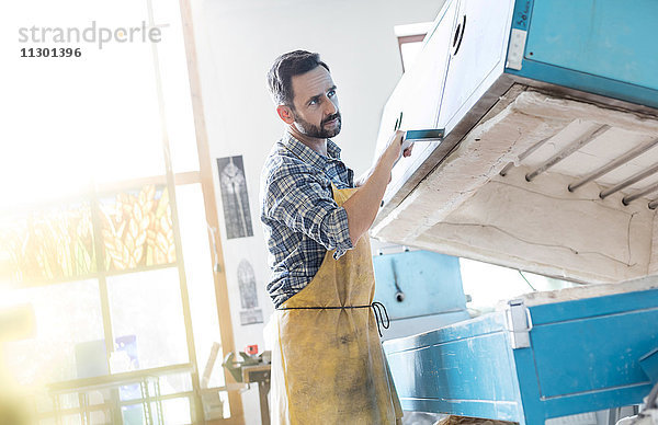 Glasmaler mit Ofen im Atelier