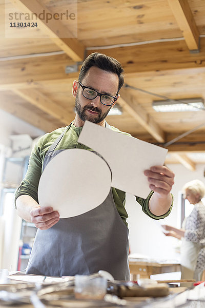 Künstlerin untersucht Stücke im Atelier