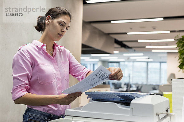 Geschäftsfrau mit Fotokopierer im Büro