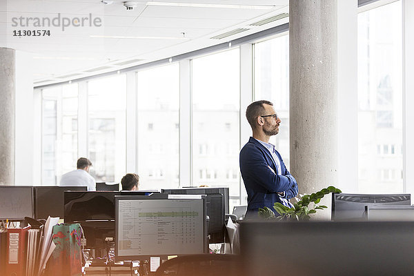 Nachdenklicher Geschäftsmann mit Blick aus dem Bürofenster