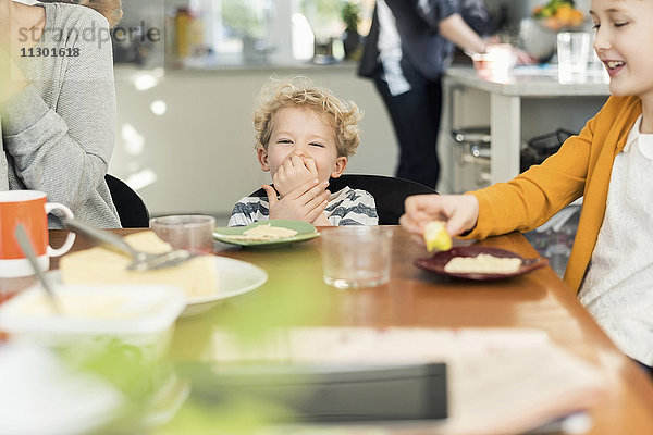 Glückliche Familie beim Frühstücken zu Hause