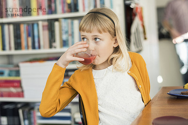 Mädchen trinken Saft zu Hause