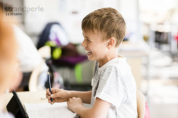 Fröhlicher Junge im Klassenzimmer der Schule