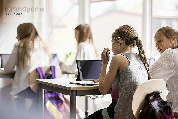 Rückansicht der Mädchen auf dem Schreibtisch im Klassenzimmer