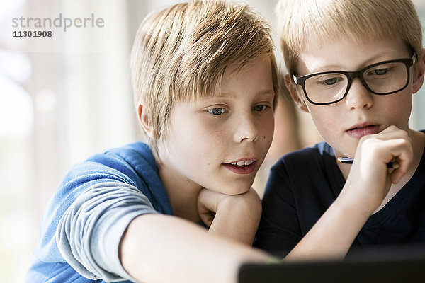 Jungen lernen vom digitalen Tablett im Klassenzimmer