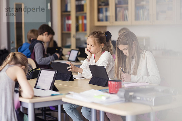 High-School-Kinder mit digitalem Tablett im Klassenzimmer