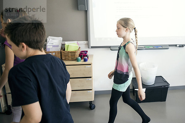 Schulkinder  die im Klassenzimmer gegen das Whiteboard laufen