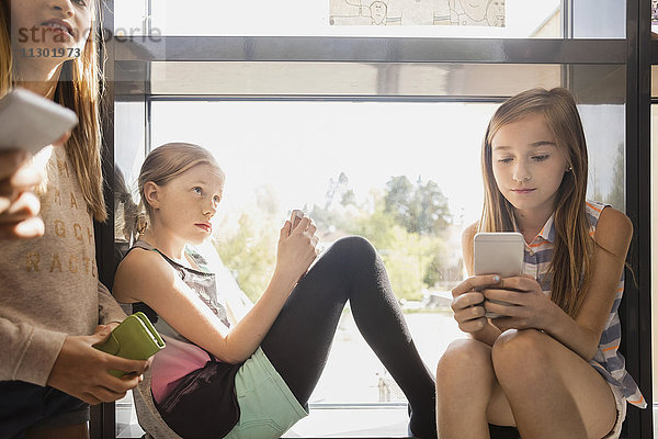 Studenten  die Mobiltelefone im Flur benutzen