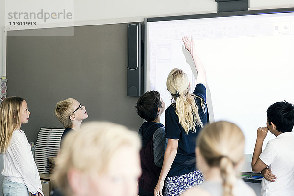 Lehrer erklärt die Schüler auf einer Tafel im Klassenzimmer