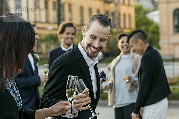 Fröhliche Freunde stoßen während der Hochzeitszeremonie auf Champagner an.