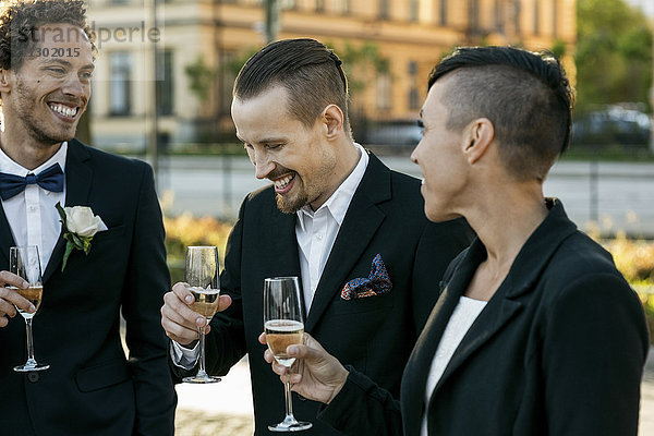 Glückliche Freunde mit Champagner bei der Hochzeitszeremonie