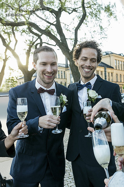 Fröhliche Freunde mit Champagner bei der Hochzeitszeremonie
