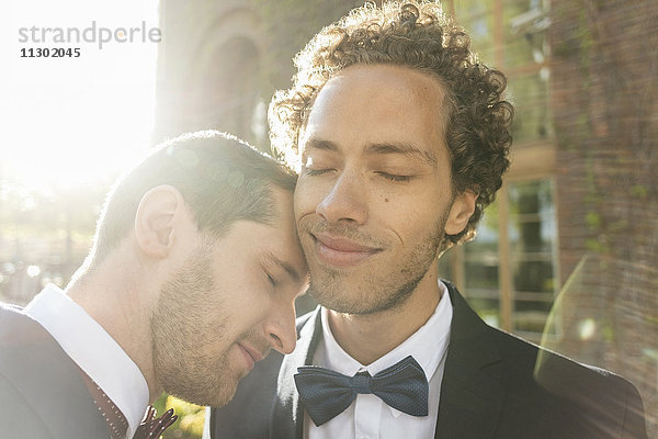 Nahaufnahme eines frisch verheirateten schwulen Paares mit geschlossenen Augen