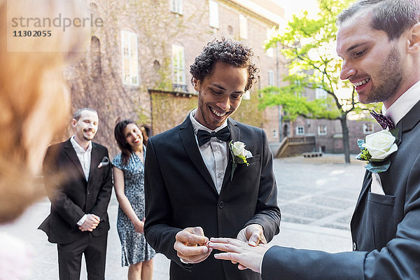 Schwules Paar tauscht Ringe während der Hochzeitszeremonie aus