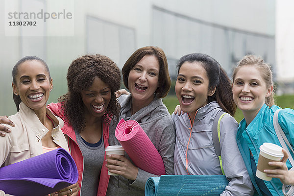 Portrait glückliche Frauen Freunde mit Yogamatten und Kaffee