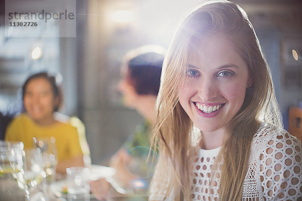 Portrait lächelnde Frau beim Essen mit Freunden im Restaurant