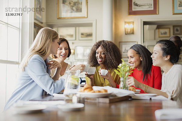 Lächelnde Frauen beim Kaffeetrinken und am Restauranttisch