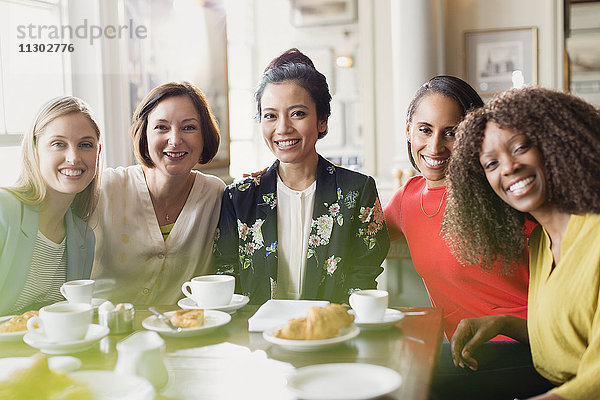 Portrait lächelnde Freundinnen beim Kaffeetrinken am Restauranttisch