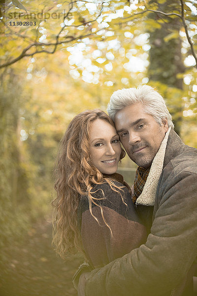Porträt zärtliches Paar  das sich im Herbstwald umarmt
