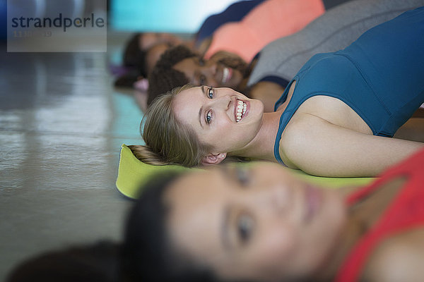 Portrait lächelnde Frauen üben Bridge-Pose im Yoga-Klasse Fitness-Studio