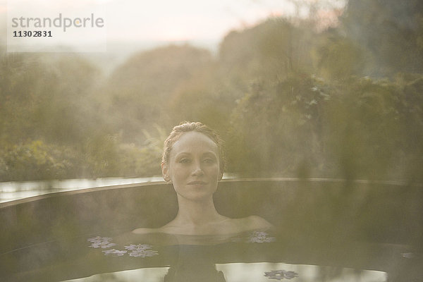 Porträt heitere Frau Einweichen im Whirlpool auf Herbst Terrasse