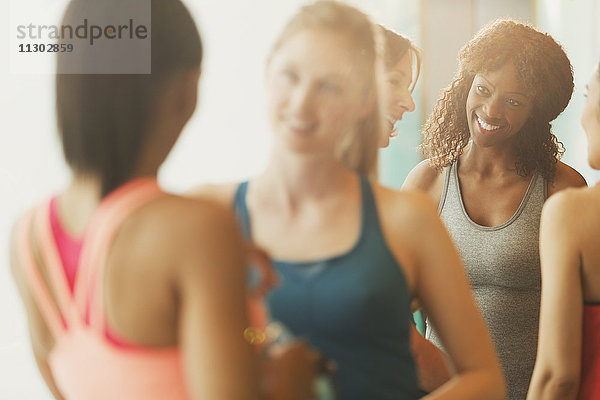 Lächelnde Frauen beim Sprechen im Fitnessstudio der Übungsklasse
