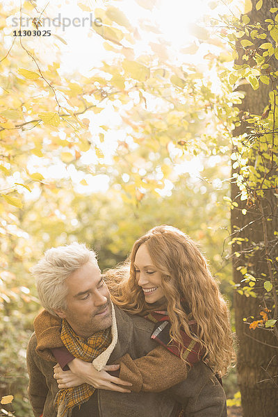 Verliebtes Paar im Herbstwald huckepack