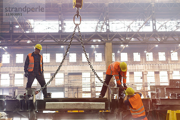 Stahlarbeiter befestigen Krankette im Werk