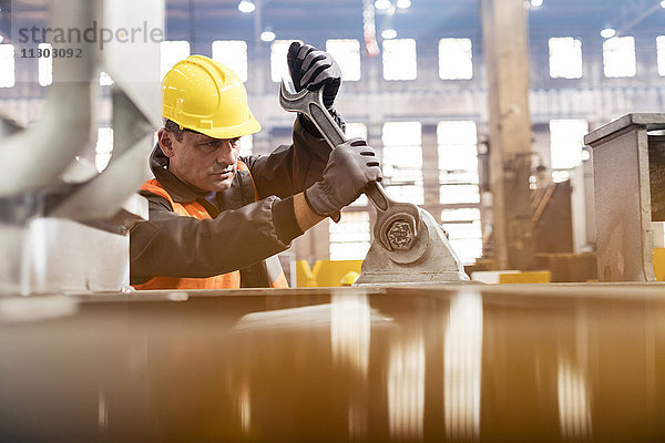 Stahlarbeiter mit großem Schraubenschlüssel im Werk