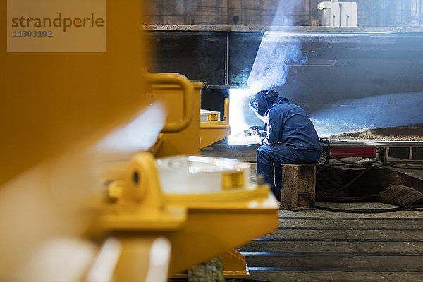 Schweißer mit Schweißbrenner im Stahlwerk