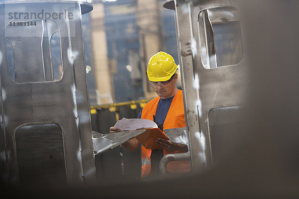 Stahlarbeiter bei der Überprüfung von Papierkram in der Fabrik