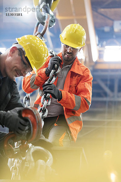 Stahlarbeiter mit Kranhaken im Werk