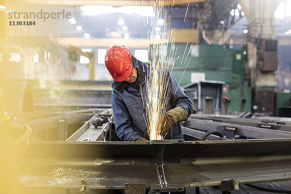 Schweißer mit Schweißbrenner im Stahlwerk