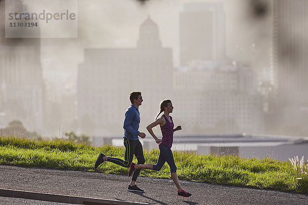 Läuferpaar auf sonnigem städtischem Bürgersteig