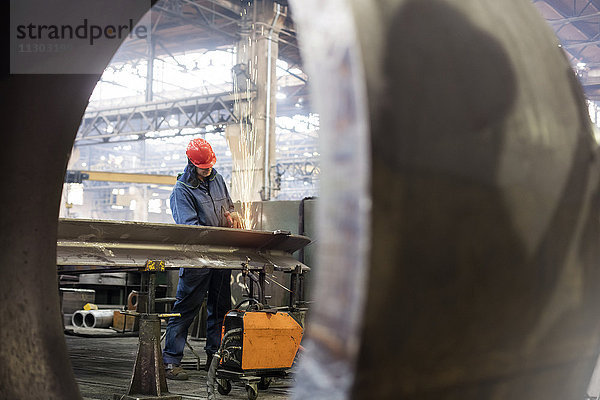 Schweißer mit Schweißbrenner im Stahlwerk