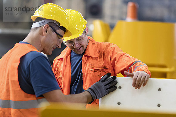 Arbeiter  die das Teil in der Fabrik untersuchen