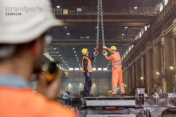 Stahlarbeiter beim Einstellen von Kranhaken im Werk