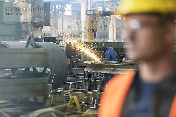 Schweißer mit Schweißbrenner im Stahlwerk