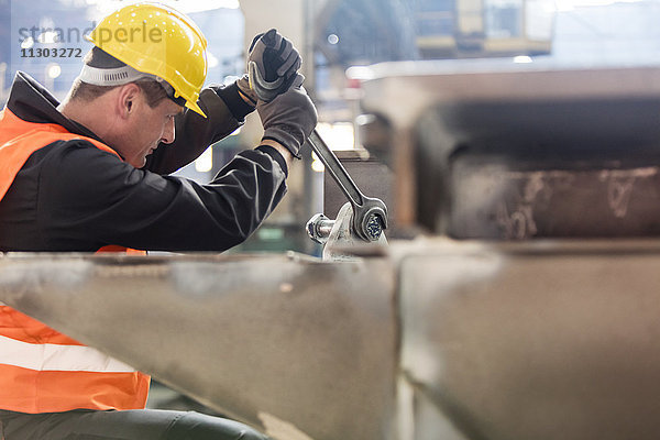 Stahlarbeiter mit großem Schraubenschlüssel im Werk