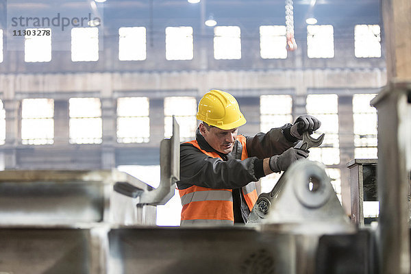 Stahlarbeiter mit großem Schraubenschlüssel im Werk