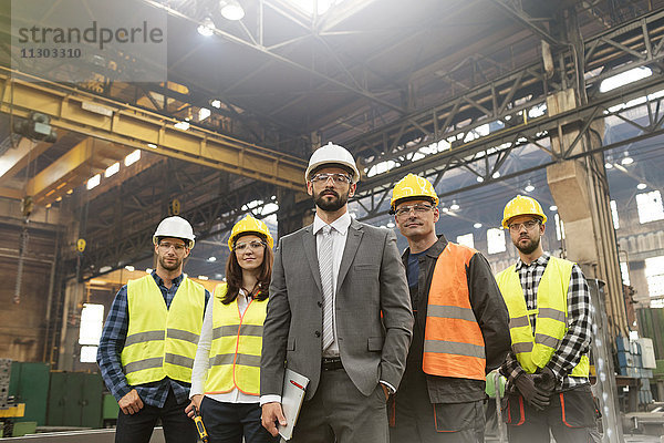 Porträt eines selbstbewussten Managers und Stahlarbeiter-Teams in der Fabrik