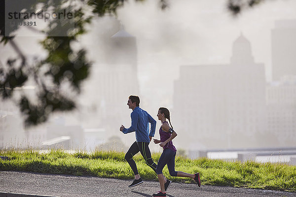 Läuferpaar läuft auf einer sonnigen städtischen Straße