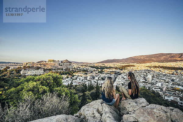 Paar auf Felsen mit Blick auf die Landschaft  Athen  Griechenland