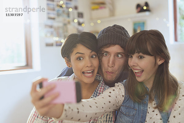 Verspielte junge Freunde machen ein Selfie mit dummen Gesichtern