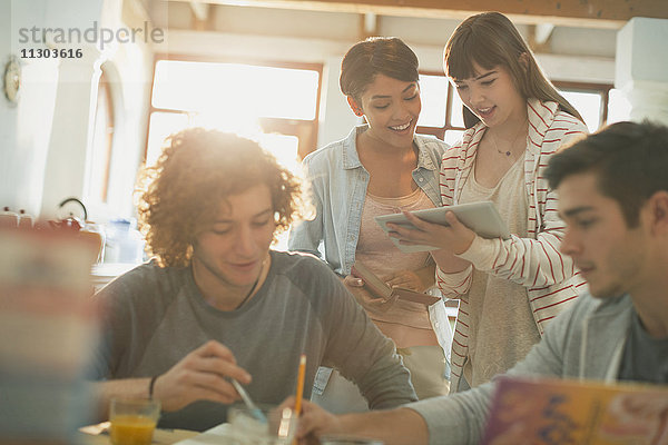 Junge Paare  die mit einem digitalen Tablet studieren