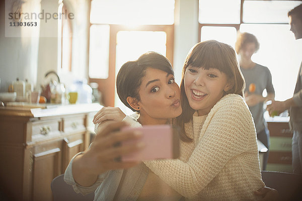 Verspielte junge Freunde nehmen Selfie mit Kamera-Handy machen ein Gesicht
